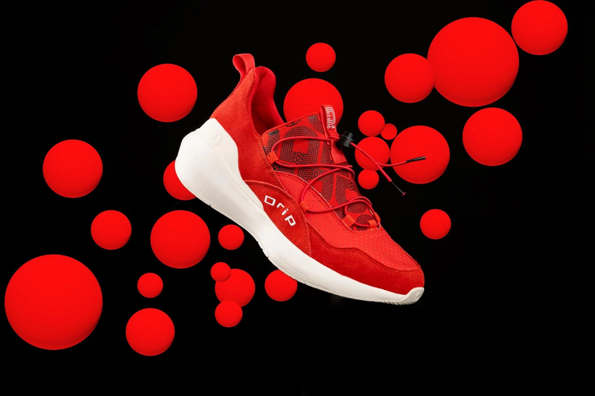 Red sneaker with white sole on a black background with red spherical elements